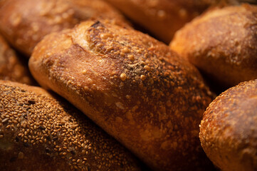 Close-up of sourdough bread. Freshly baked bread with a golden crust on the wooden shelves of the bakery. The context of a German artisan bakery with an assortment of rustic breads.