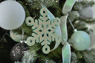 A beautiful New Year's interior with a large, decorated with toys standing near the fireplace.