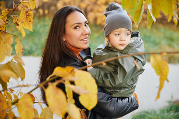 beautiful woman with a baby in her arms. in the park