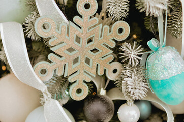 A beautiful New Year's interior with a large, decorated with toys standing near the fireplace.