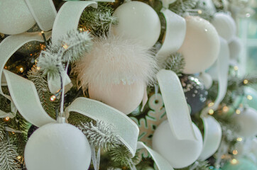 A beautiful pink ball with a fluff decorates a Christmas tree.