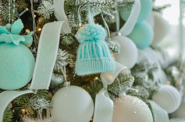 A toy blue hat on a Christmas tree.