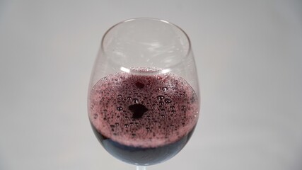 glass of red wine served in a tasting big cup to decant the wine after opening the bottle - Italian...