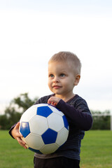 a little boy playing football on the field