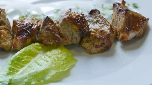 Tasty beef shish kebab barbecue on a plate ready for dinner. Grilled meat rotating