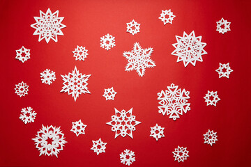Naklejka na ściany i meble Christmas decoration with white paper snowflakes on red