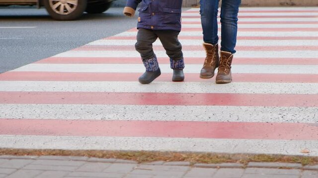 Mom and child cross the road at the zebra crossing.