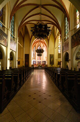 Główny korytarz w kościele. Widok na ołtarz i ławki dla wiernych.  - obrazy, fototapety, plakaty