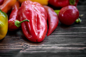 Colorful peppers on the wooden background. Copy space.