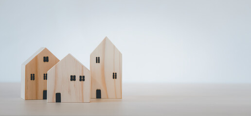 Obraz na płótnie Canvas Mini wood house model from model on wood table, Planning buy Real Estate, Planning to buy property and Choose the best. work from home and stay at home concept.