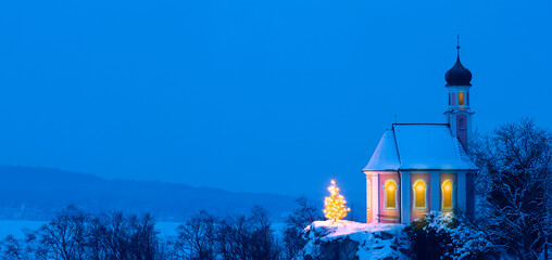 Romantische Weihnachtskapelle mit Christbaum im Schnee