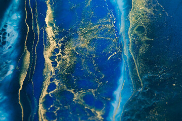 Resin art with dark blue and golden tones. Epoxy effect background