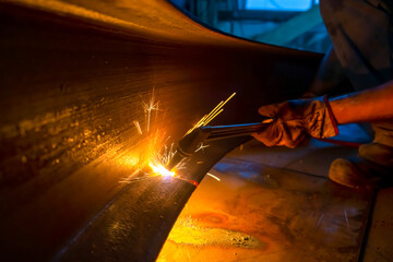 A worker cuts a beam with a gas cutter.