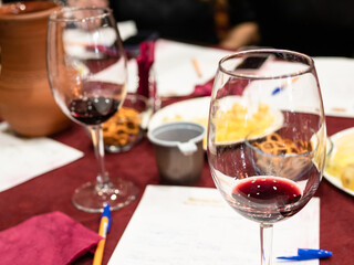 red grape wine tasting - wineglasses with tested wines and memo paper on table