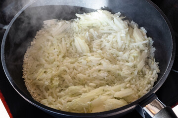 finely chopped onions sauteing in deep frying pan at home kitchen