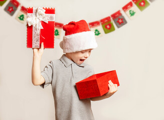 Happy child in Santa hat opening Christmas gift box