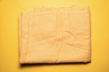 Golden color fabric cloth on the yellow background.