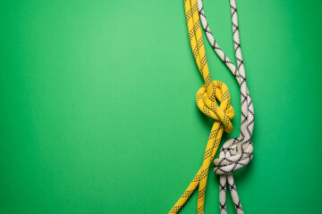 Climbing rope on the green flat lay background with copy space.