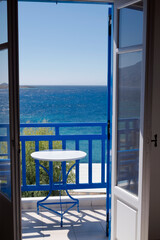Fototapeta na wymiar View through the window of the Aegean sea and blue balcony railings typical in Greece. Photo taken in Koufonisia island 