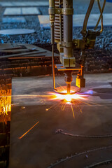 Gas cutting of sheet steel on a machine with numerical control. Splashes of molten metal.