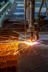 Gas cutting of sheet steel on a machine with numerical control. Splashes of molten metal.