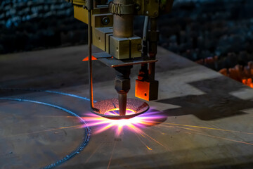 Gas cutting of sheet steel on a machine with numerical control. Splashes of molten metal.