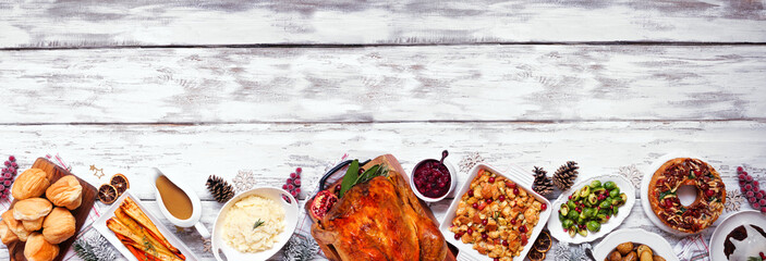 Classic Christmas turkey dinner. Above view bottom border on a white wood banner background....