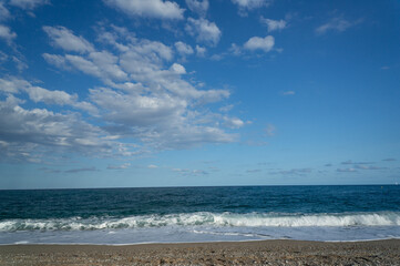 summer day at a beach. view of the sea with waves at a sunny day