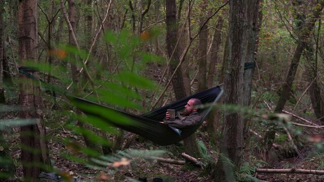A man relaxing in a hammock in the woods