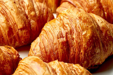 Close-up texture of freshly baked croissants on a white background. Many croissons pattern