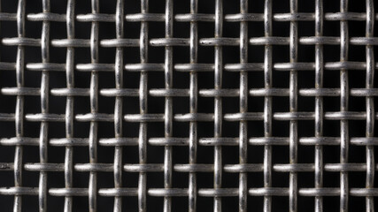 metal protective grille isolated on black, geometric background texture for designing, seamless pattern of wire fence or net structure closeup view