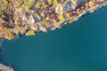 View of the artificial lake in a flooded part of a granite quarry lined with stone