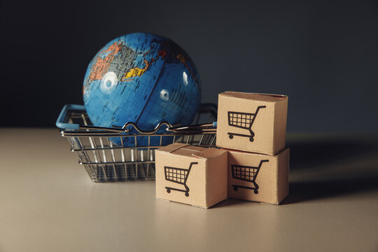 Globe in supermarket shopping basket with boxes. World trade and delivery of purchases
