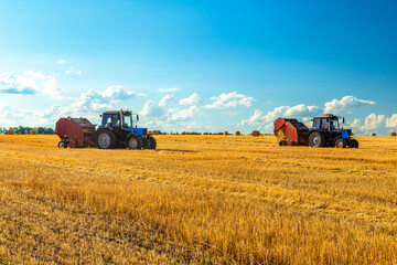 Bales of Hay in the Countryside and Tractor at Work in the background