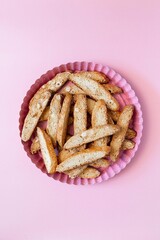 Biscotti with nuts on pink background. Delicious cantucci cookies. Cantuccini. Traditional italian homemade dry crispy biscuits.