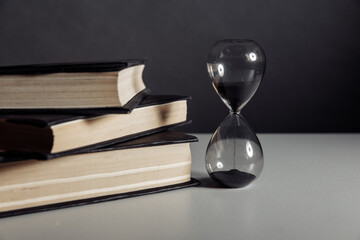 Hourglass and books on a table
