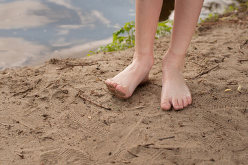 Fototapeta na wymiar children's feet barefoot close up without socks and shoes on the sand on the beach