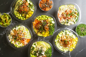 poke salad take away food on black marble background Seen from above