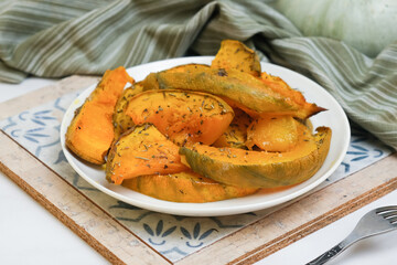 Plate of baked pumpkin with provencal herbs. Seasonal healthy vegetarian autumn Thanksgiving food.