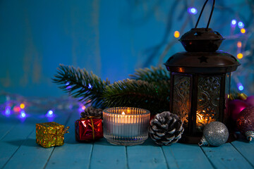 Candle, decor and Christmas tree on the background of Christmas lights.