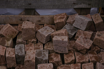 Brown cobblestones in a wooden pallet in the rain.