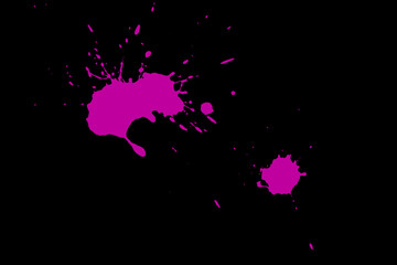 Pink blot on a black background. Spots of paint on a piece of paper.