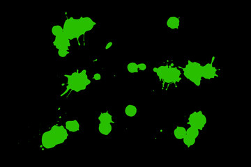 Green blot on a black background. Spots of paint on a piece of paper.