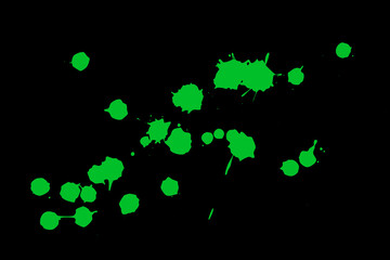 Green blot on a black background. Spots of paint on a piece of paper.