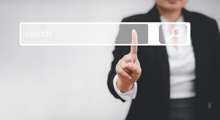 Businesswoman clicking internet search page on a computer touch screen or blank search bar,  internet and technology concept, Analysis the Internet to connect wirelessly, search engine optimization.