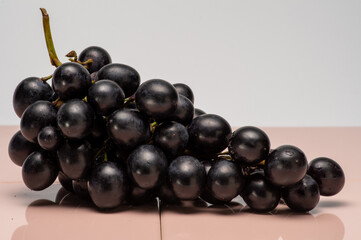 red grapes isolated on pink  tile