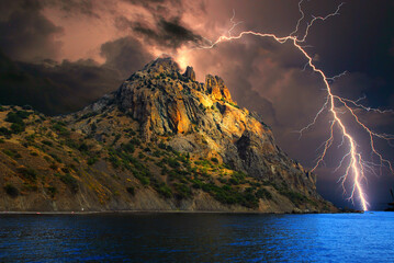 Lightning flashes over the rocky coast of the Black Sea during a thunderstorm.  A storm with...