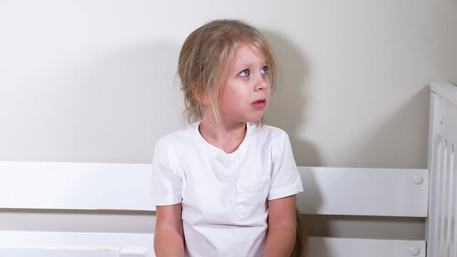 The child looks at the offender in fear. The girl is scared. Child abuse. Psychological problems in the family. Psychological pressure on the child. They shout at the child.