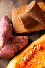 Pumpkin, Sweet potatos Camote and unprocessed sugar cane Piloncillo. Raw Ingredients for mexican traditional dessert for dia de muertos. Close up on rustic wooden table