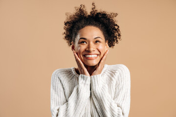 Oh my god, wow. Portrait of surprised woman looking up with toothy smile and in amazement, expressing shock, astonishment. Indoor studio shot, white background